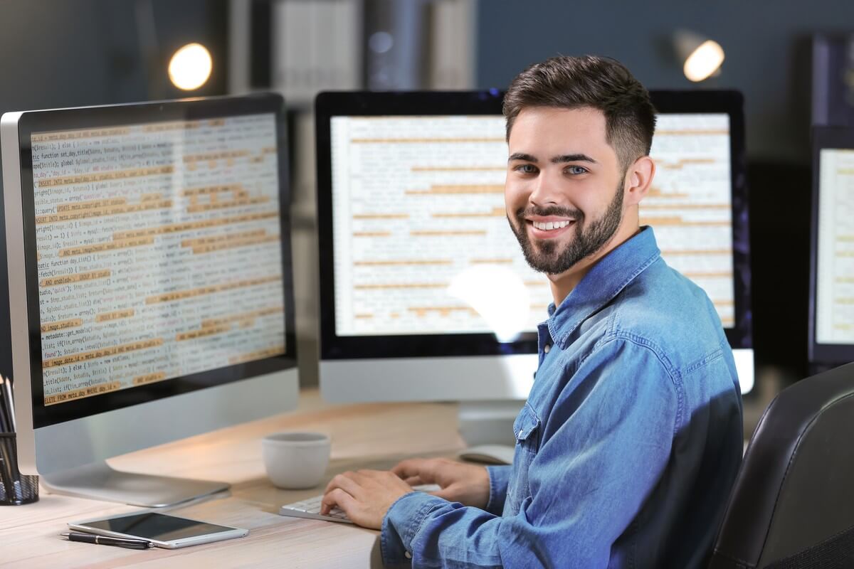 Ein Mann sitzt am Computer mit geöffneter Anwendersoftware.
