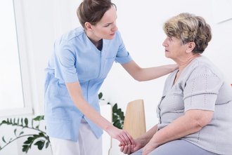 Eine Pflegerin im Gespräch mit einer Patientin.