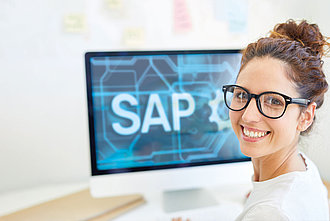 Eine Frau sitzt an einem Computer mit SAP-Programm.